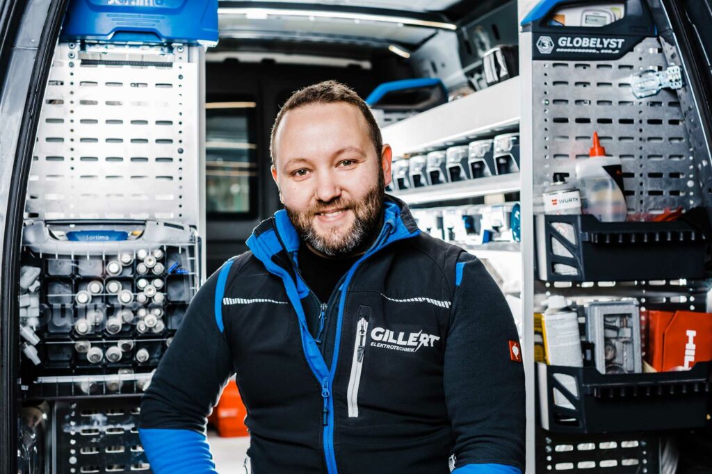 Handwerker lächelt im Werkstattwagen.