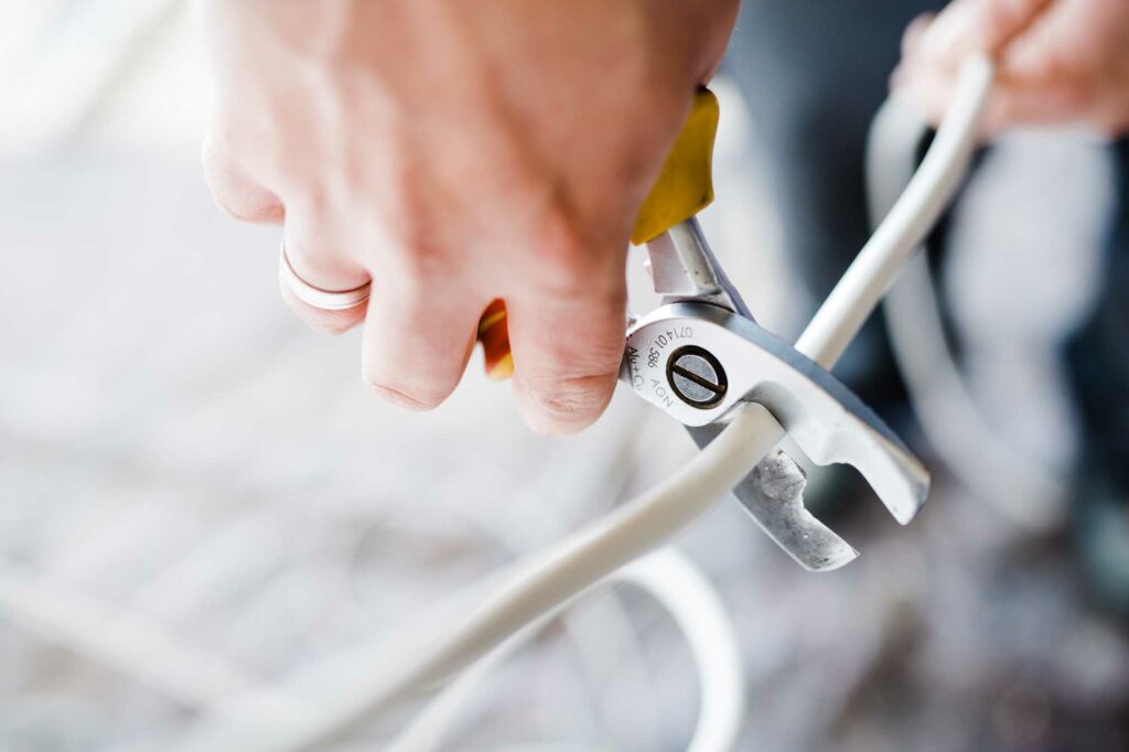 Kabel wird mit Zange durchtrennt.