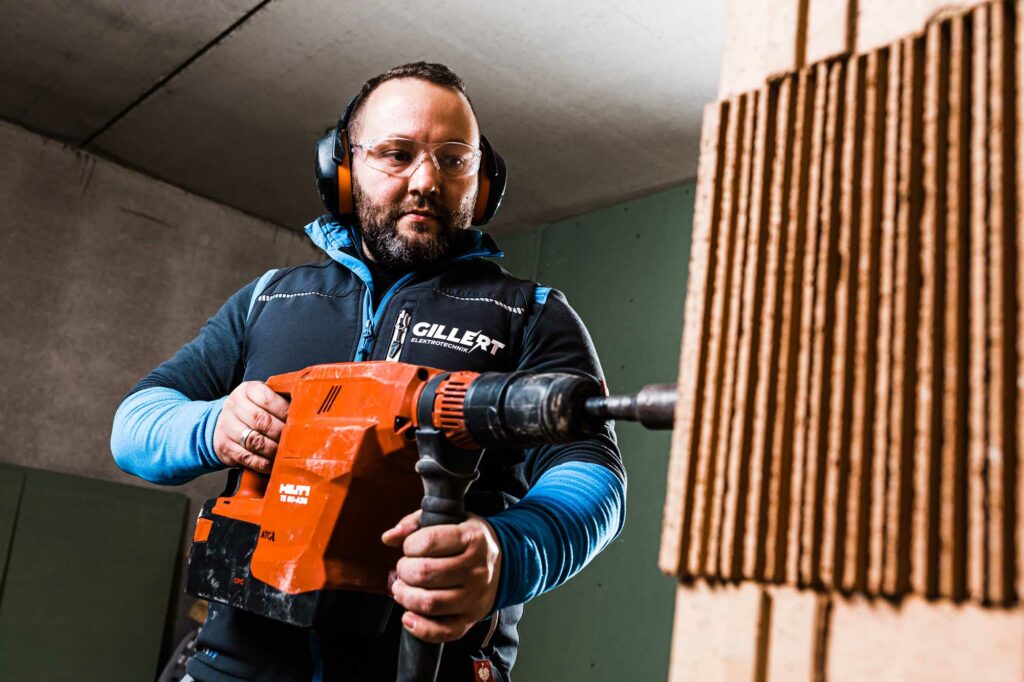 Bohrt konzentriert Loch in Wand.