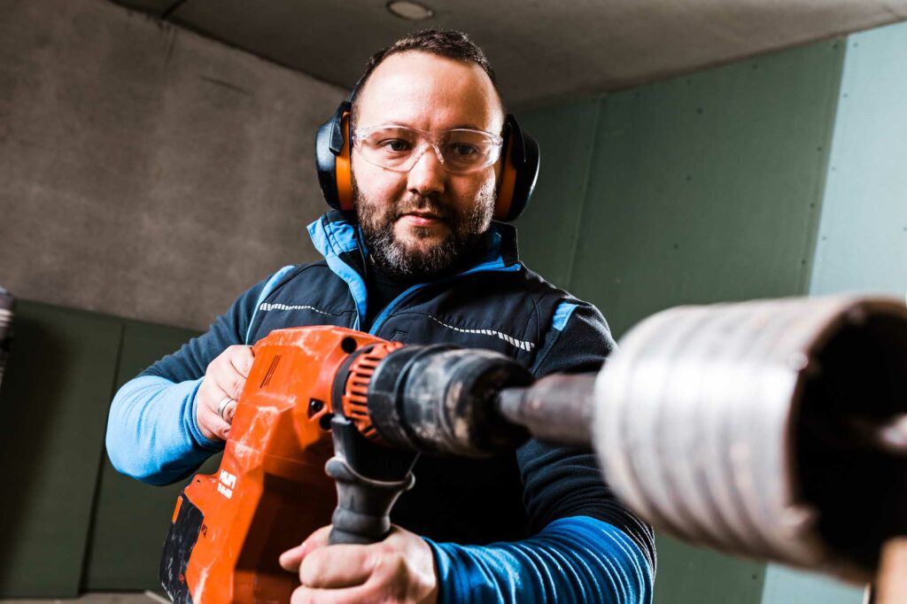Schutzbrille, Bohrer, konzentrierter Handwerker, Werkstatt.