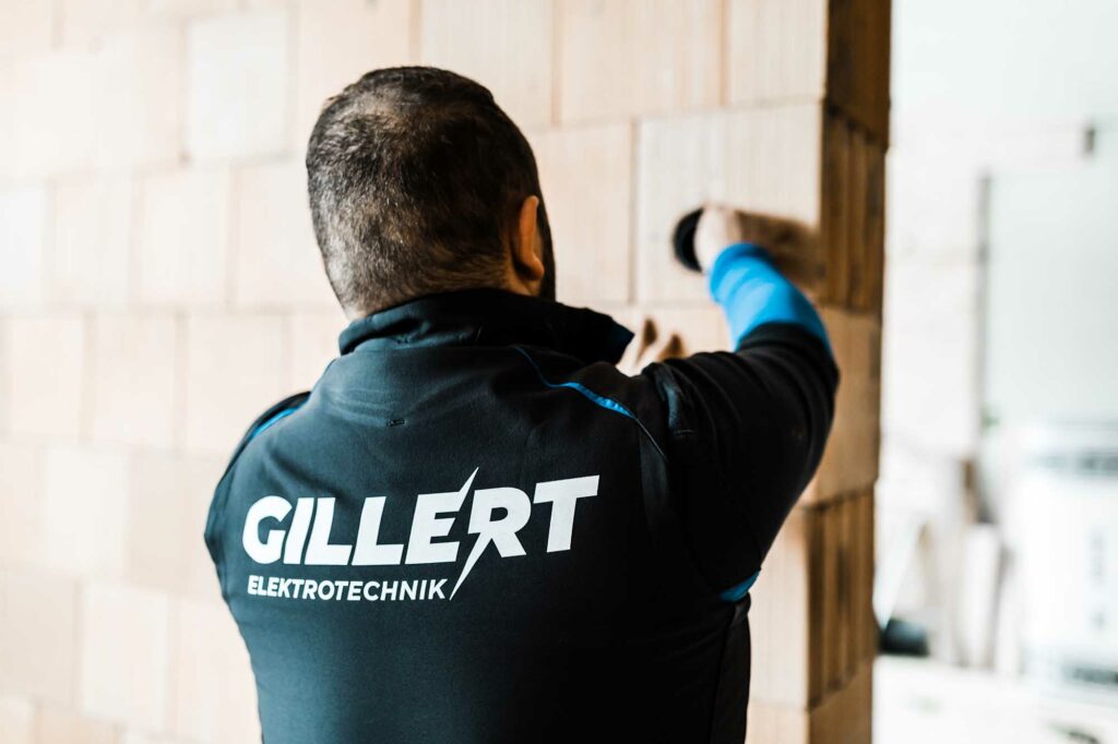 Elektriker arbeitet an Ziegelwand.